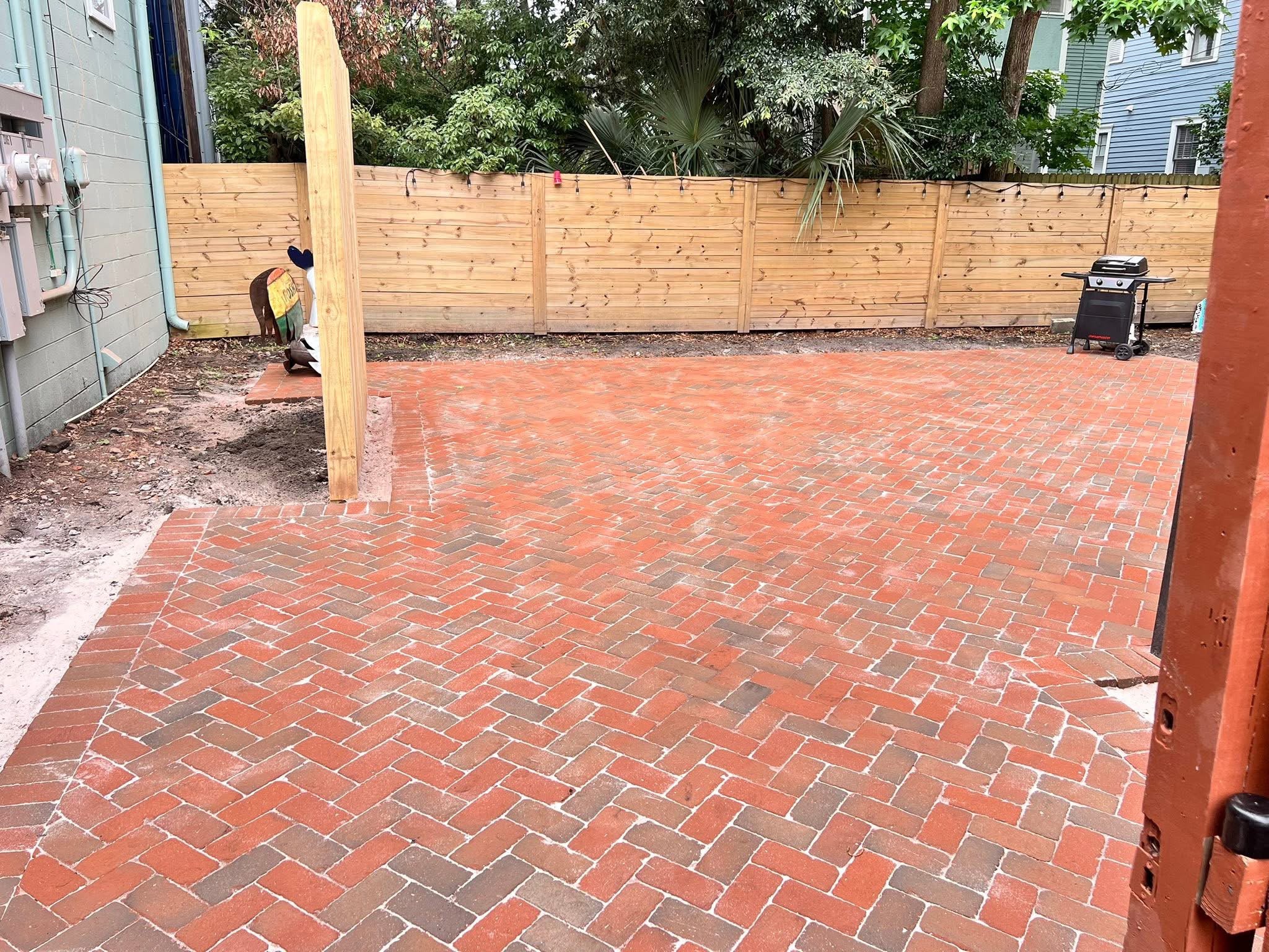 Reclaimed brick courtyard patio laid in herringbone behind a Savannah home